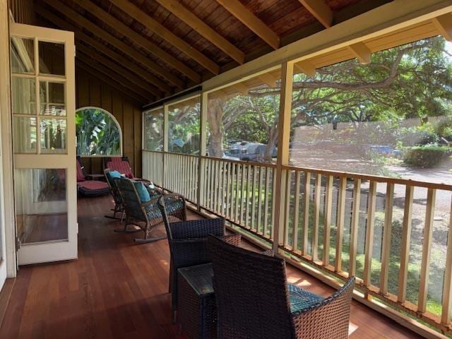 sunroom featuring a wealth of natural light and lofted ceiling with beams