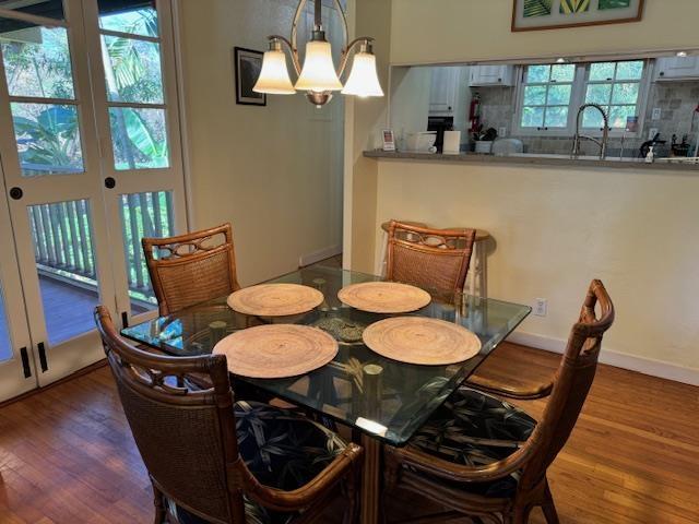 dining room with sink, an inviting chandelier, and hardwood / wood-style flooring