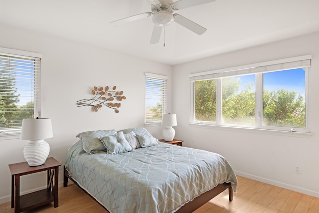 bedroom with wood finished floors, baseboards, and ceiling fan
