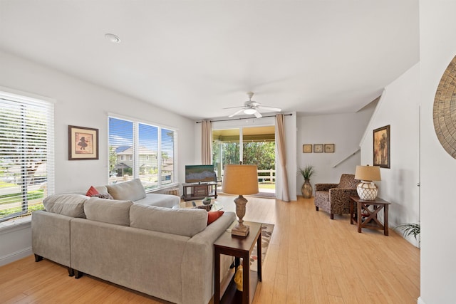 living room featuring light wood finished floors, ceiling fan, and baseboards