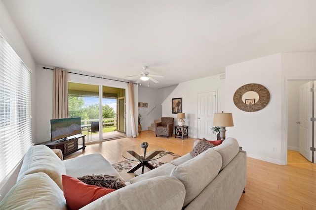 living area with a ceiling fan, light wood-style floors, and baseboards