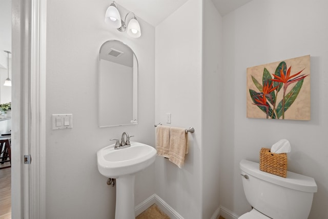 half bathroom with toilet and baseboards