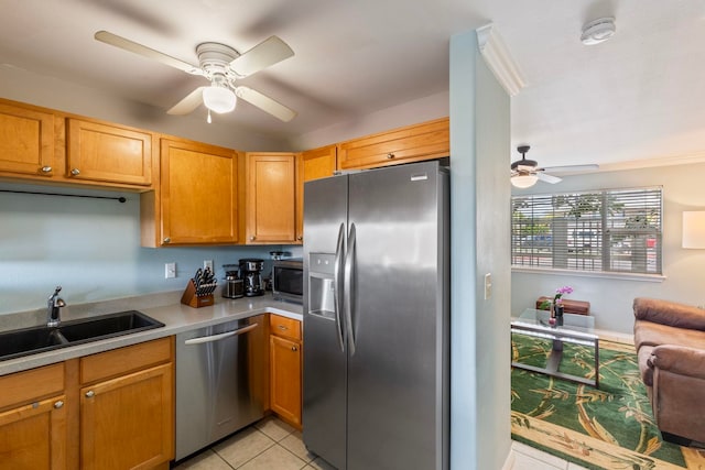 kitchen featuring a sink, open floor plan, appliances with stainless steel finishes, light countertops, and light tile patterned floors