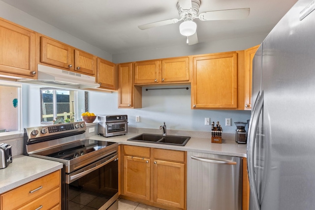 kitchen with under cabinet range hood, light countertops, appliances with stainless steel finishes, a ceiling fan, and a sink