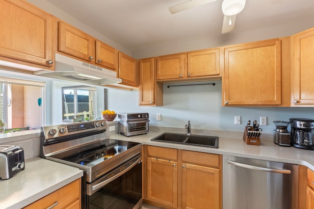 kitchen featuring a ceiling fan, a sink, light countertops, under cabinet range hood, and appliances with stainless steel finishes