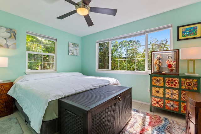 bedroom featuring tile patterned floors, multiple windows, and ceiling fan