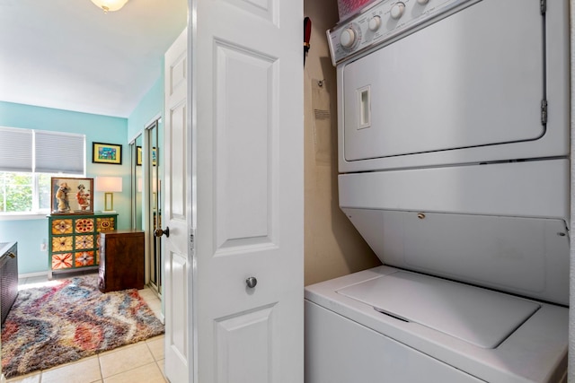 washroom featuring light tile patterned floors, laundry area, and stacked washer and clothes dryer