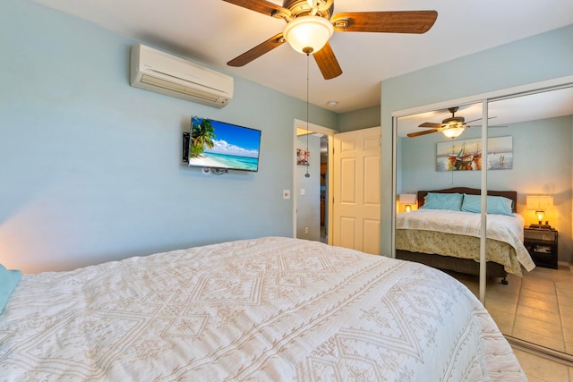 bedroom with a wall unit AC, a closet, tile patterned floors, and ceiling fan