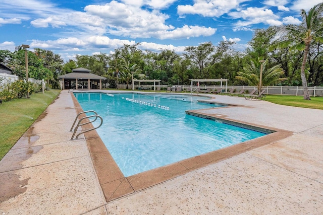 community pool featuring a gazebo, a patio area, and fence