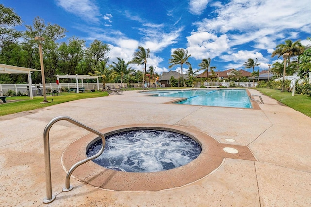 pool with a community hot tub, a patio, and fence