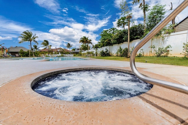 view of swimming pool with an in ground hot tub, a fenced in pool, and fence