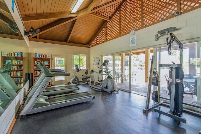 workout area with high vaulted ceiling, wood ceiling, and concrete block wall