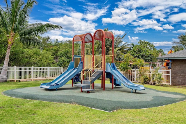 communal playground featuring a yard and fence