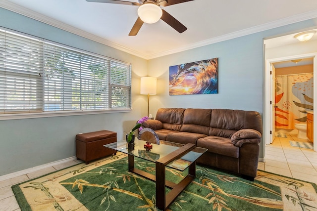 living room featuring tile patterned flooring, baseboards, crown molding, and ceiling fan