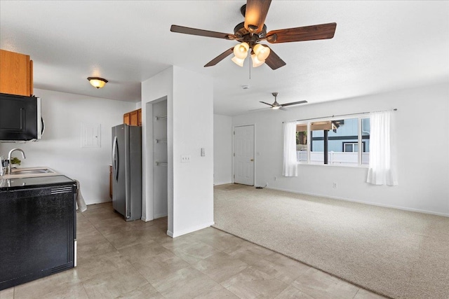 kitchen featuring stainless steel refrigerator, sink, electric range, ceiling fan, and light colored carpet