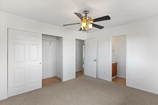 unfurnished bedroom with light carpet, ensuite bath, ceiling fan, and a closet