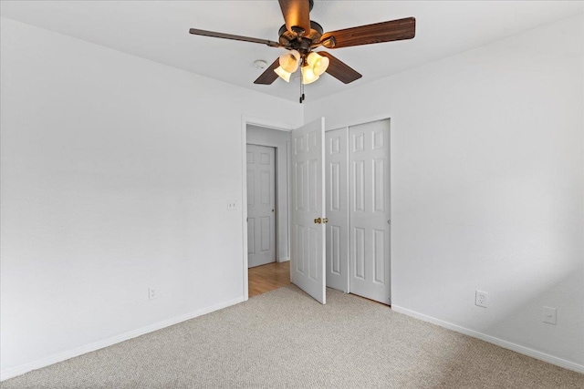 unfurnished bedroom featuring a closet, ceiling fan, and light carpet