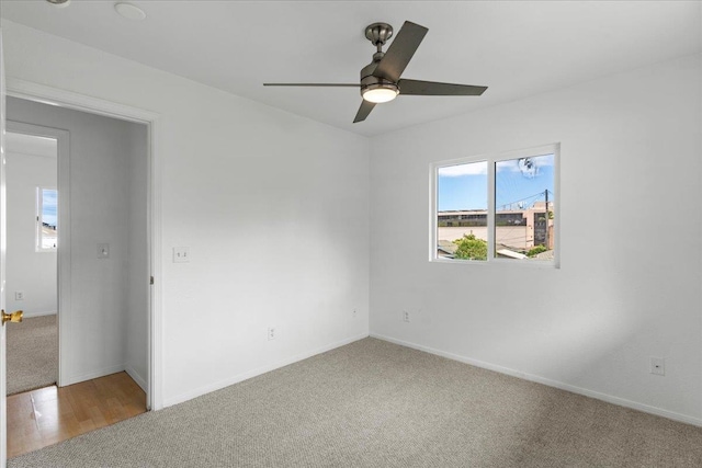 carpeted spare room with ceiling fan