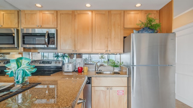 kitchen featuring light stone counters, stainless steel appliances, sink, light brown cabinets, and light tile patterned flooring