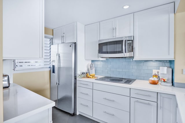 kitchen featuring white cabinetry, light countertops, appliances with stainless steel finishes, and decorative backsplash