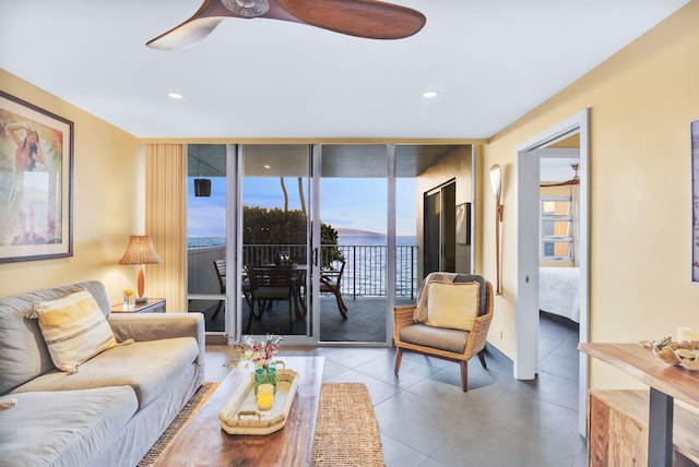 living area with tile patterned flooring, recessed lighting, a wall of windows, and ceiling fan