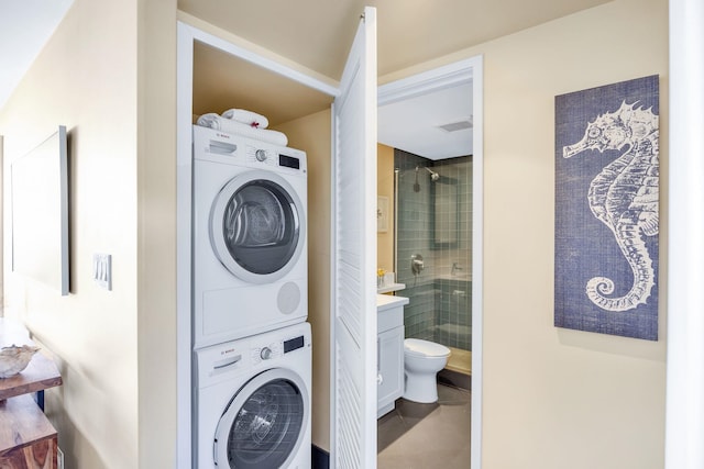 clothes washing area featuring laundry area, stacked washer and dryer, visible vents, and tile patterned floors