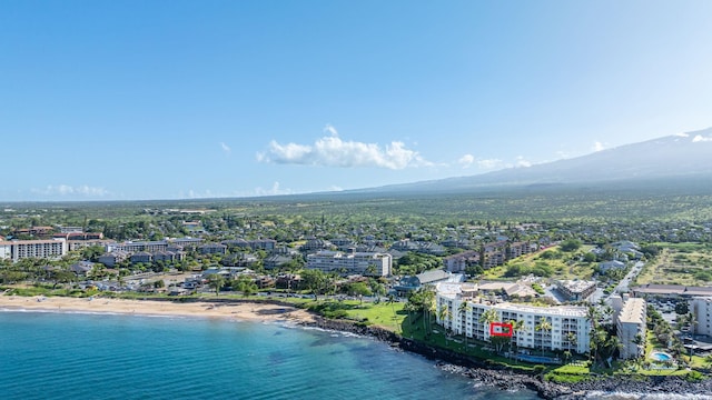 drone / aerial view with a water and mountain view and a beach view