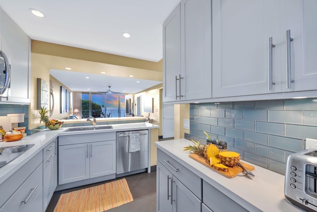 kitchen featuring a sink, decorative backsplash, stainless steel dishwasher, and light countertops