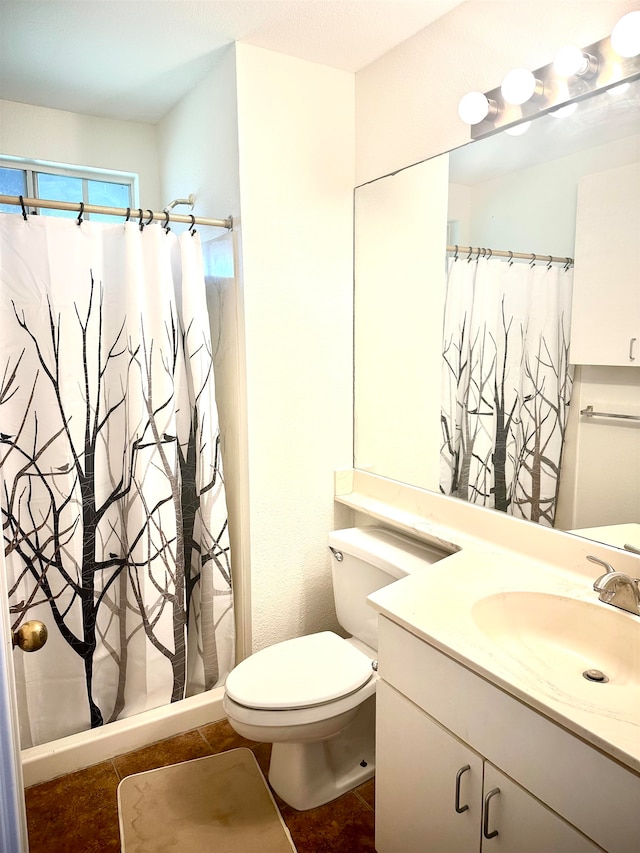 bathroom with tile patterned flooring, walk in shower, vanity, and toilet