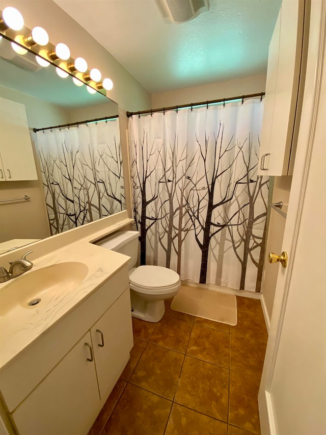 bathroom with tile patterned floors, a shower with curtain, vanity, and toilet