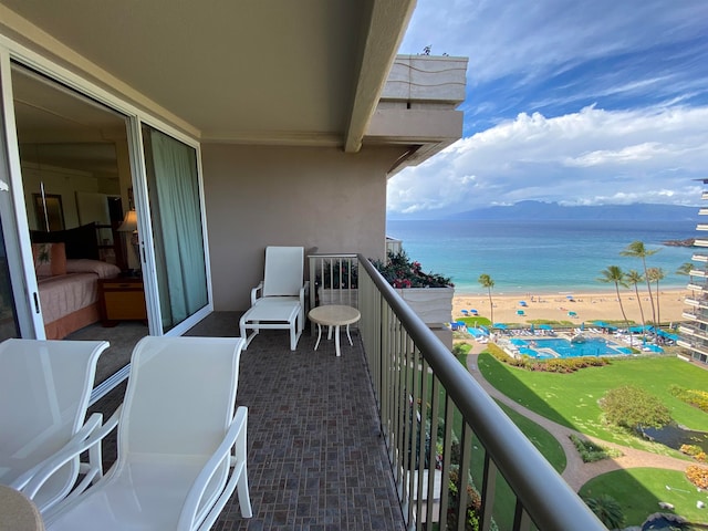 balcony with a water view and a beach view