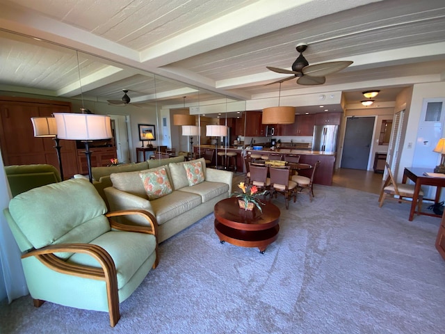 carpeted living room featuring ceiling fan and beam ceiling