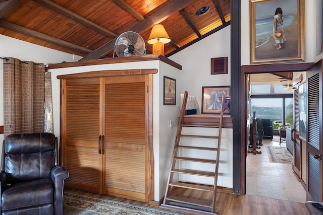 stairway featuring beamed ceiling, wood-type flooring, high vaulted ceiling, and wooden ceiling