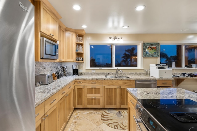 kitchen with light stone countertops, sink, stainless steel appliances, decorative backsplash, and light tile patterned floors