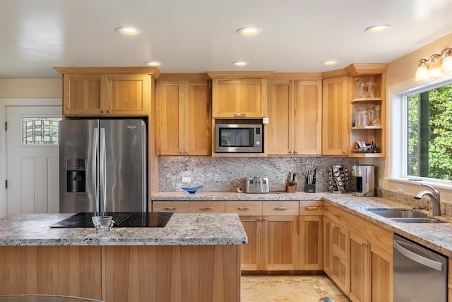 kitchen with backsplash, light stone countertops, sink, and appliances with stainless steel finishes