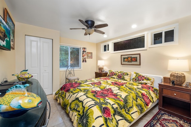 bedroom with ceiling fan, light tile patterned flooring, and a closet