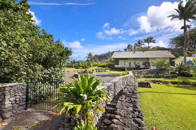 140 Waikoloa Rd, Hana, HI 96713 - view of green lawn with a gate and covered porch
