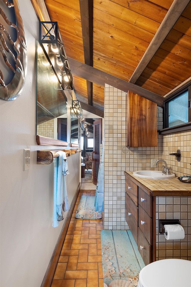 kitchen featuring backsplash, lofted ceiling with beams, sink, tile walls, and wood ceiling