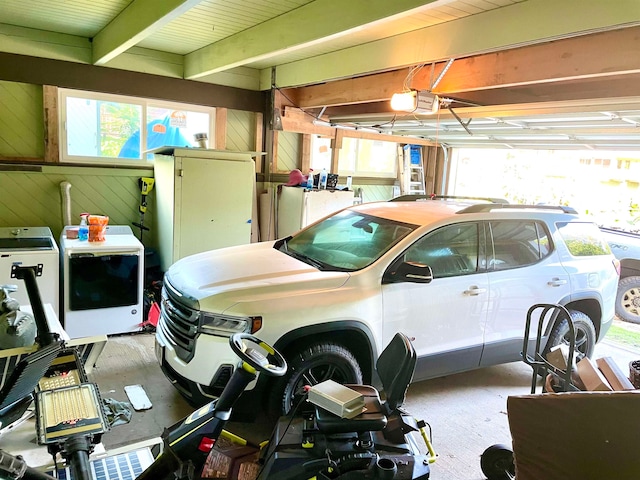 garage with washer / dryer, a garage door opener, and wood walls