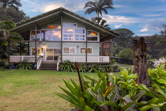 back of property featuring a lawn and a deck