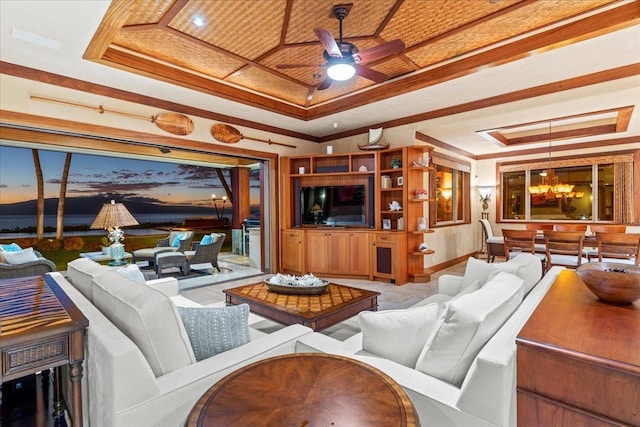 living room with crown molding, ceiling fan, and a raised ceiling