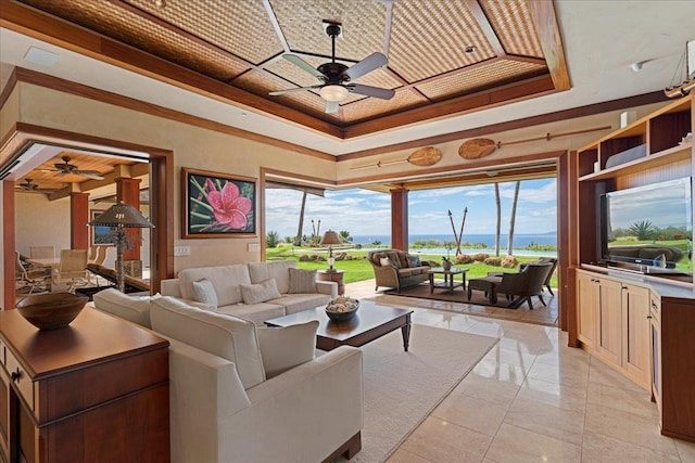 living room featuring crown molding, a raised ceiling, and ceiling fan