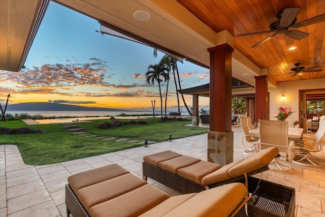 85 Lau Awa Pl, Lahaina, HI 96761 - patio terrace at dusk with a patio area, a ceiling fan, a yard, outdoor dining area, and an outdoor living space