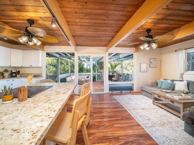 sunroom with track lighting, wooden ceiling, a wealth of natural light, and beamed ceiling