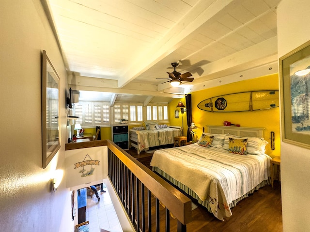 bedroom featuring beamed ceiling, hardwood / wood-style floors, and ceiling fan