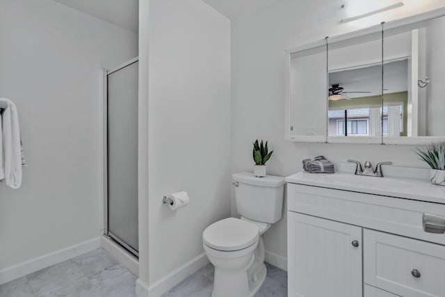 bathroom featuring ceiling fan, vanity, a shower with door, and toilet