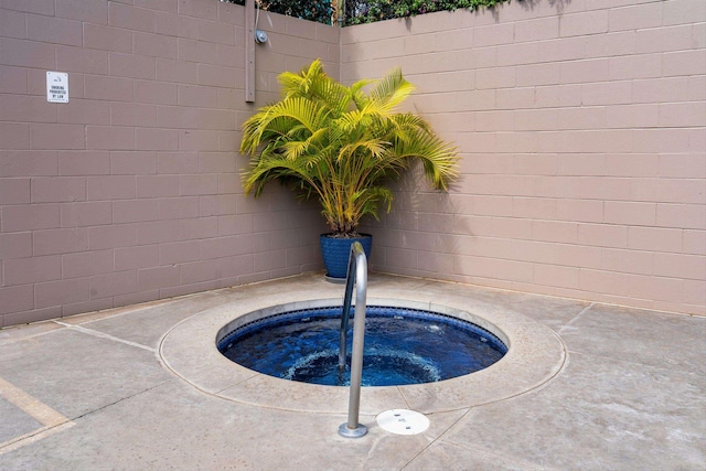 view of swimming pool featuring a hot tub