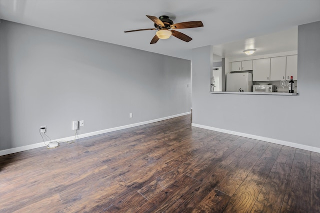 unfurnished living room with ceiling fan and dark hardwood / wood-style flooring