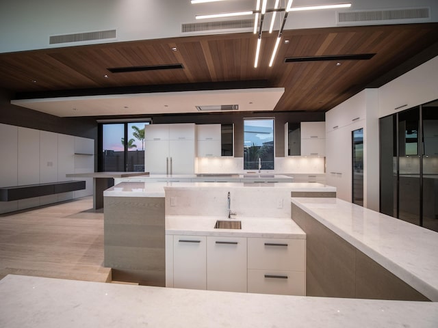 kitchen featuring light hardwood / wood-style floors, tasteful backsplash, white refrigerator, wood ceiling, and white cabinets