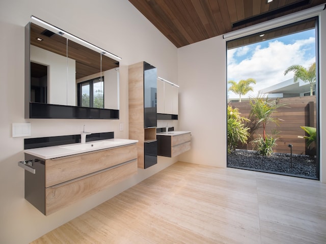 interior space with wooden ceiling, sink, white cabinets, and light hardwood / wood-style flooring